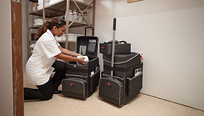 Hotel housekeeping lady loads clean towels into Rubbermaid Quick Carts
